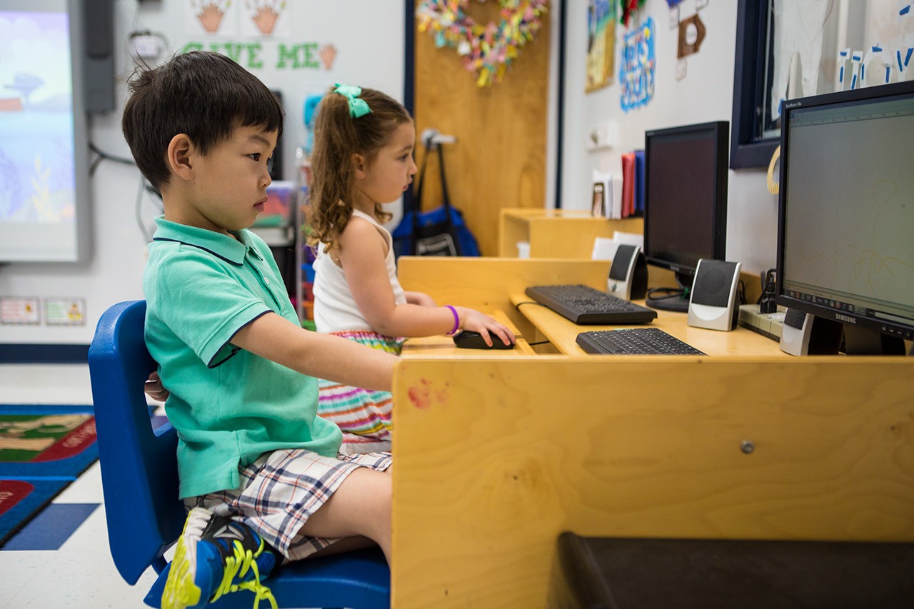 Two children use desktop computers in a Computer Lab.